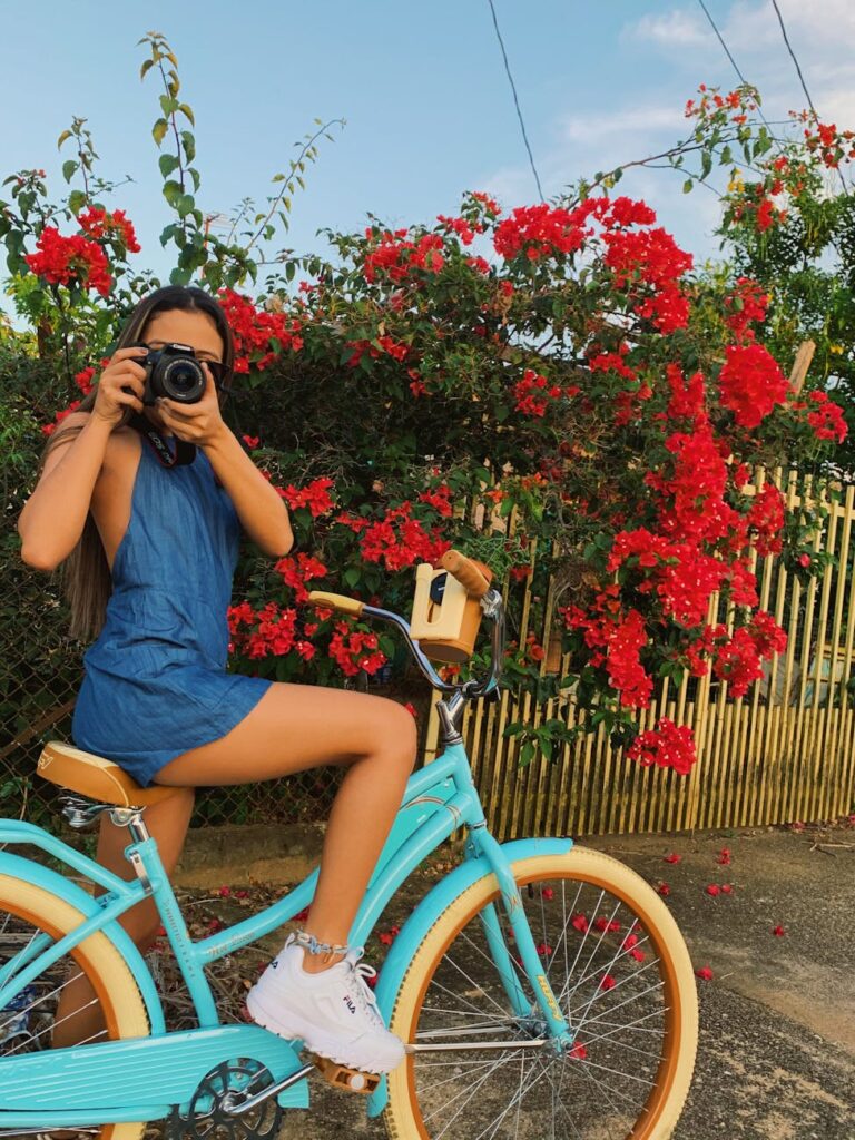 woman seated on bike using camera