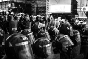 grayscale photo of people with shields and helmets