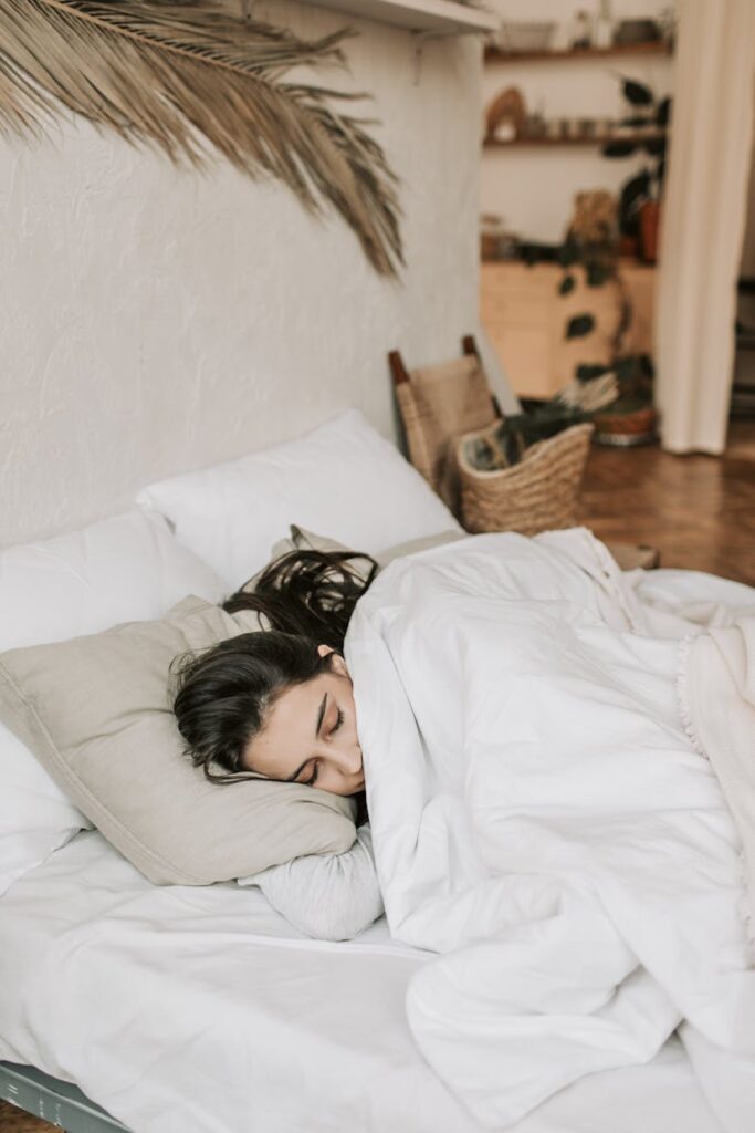woman sleeping on a bed with white blanket