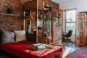 cozy bedroom with comfortable bed and work zone near brick wall