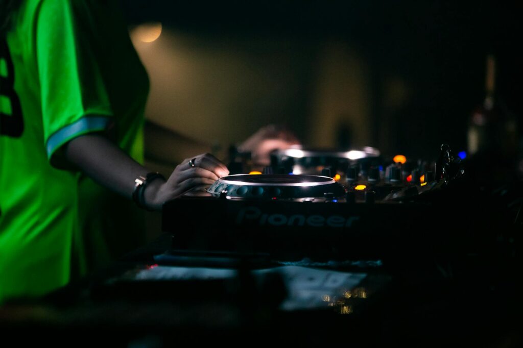 close up of a dj mixing music on a dj controller
