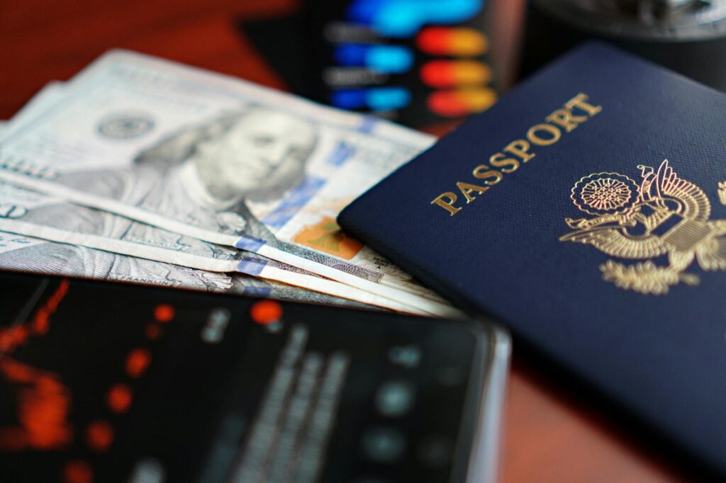 close up of passport dollars and smartphone