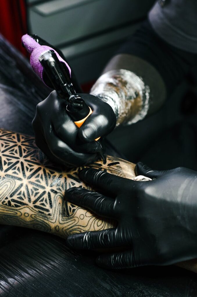 selective focus photography of tattoo artist drawing a tatoo