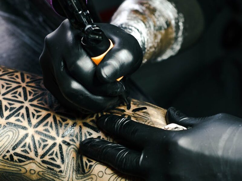 selective focus photography of tattoo artist drawing a tatoo