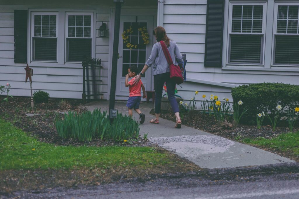 woman and boy in front of house
