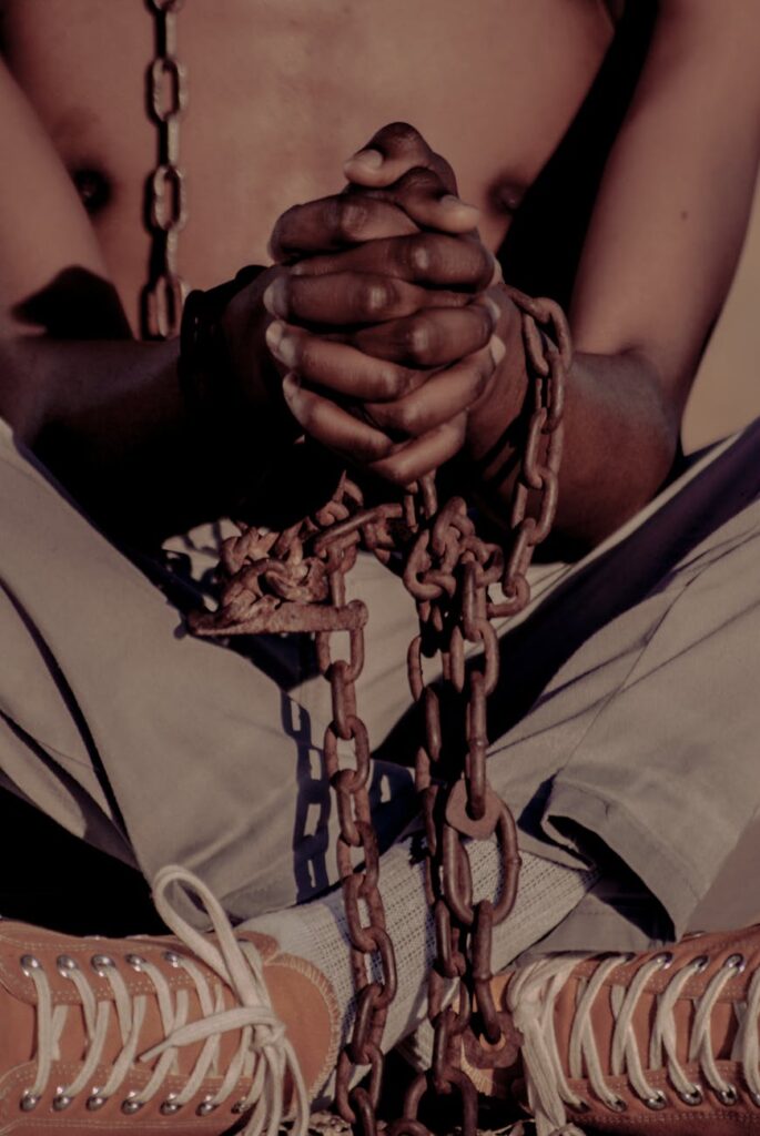 person sitting cross legged with chain around hands