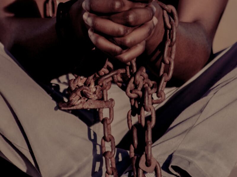 person sitting cross legged with chain around hands