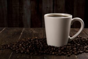 coffee mug surrounded with coffee beans