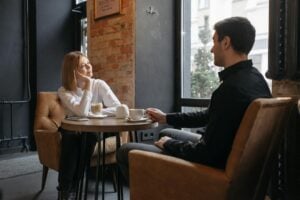 man and woman sitting on sofa chair at the coffee shop