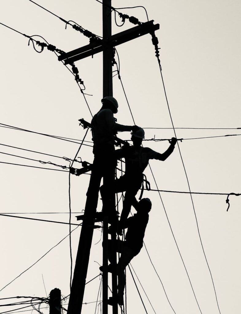 utility workers silhouette repairing power lines
