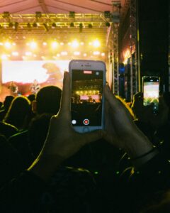 man making a video recording of a concert with a smart phone