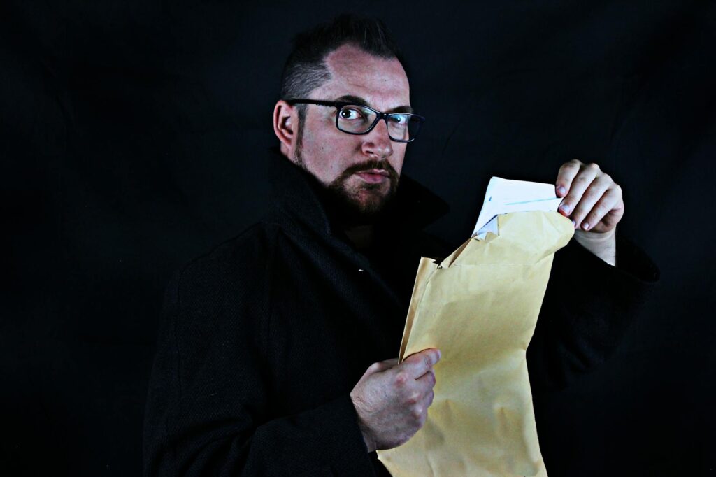 man holding brown envelope