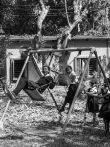 children playing joyfully on a swing outdoors