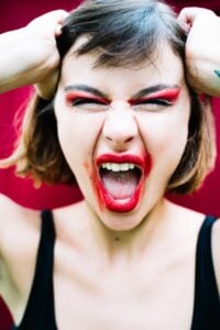 woman in red makeup screaming