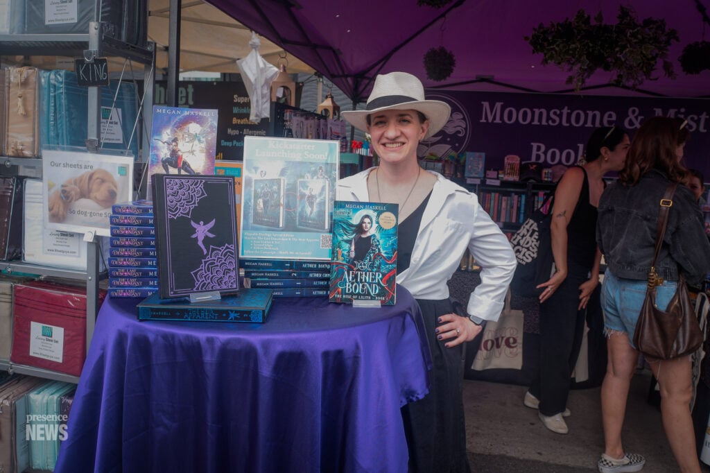 Author Meghan Haskell greets visitors at the Moonstone & Mist Bookshop booth during Fiesta Hermosa. (Photo by Maria Cornejo / Presence News)