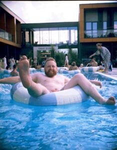 man relaxing on pool float in resort