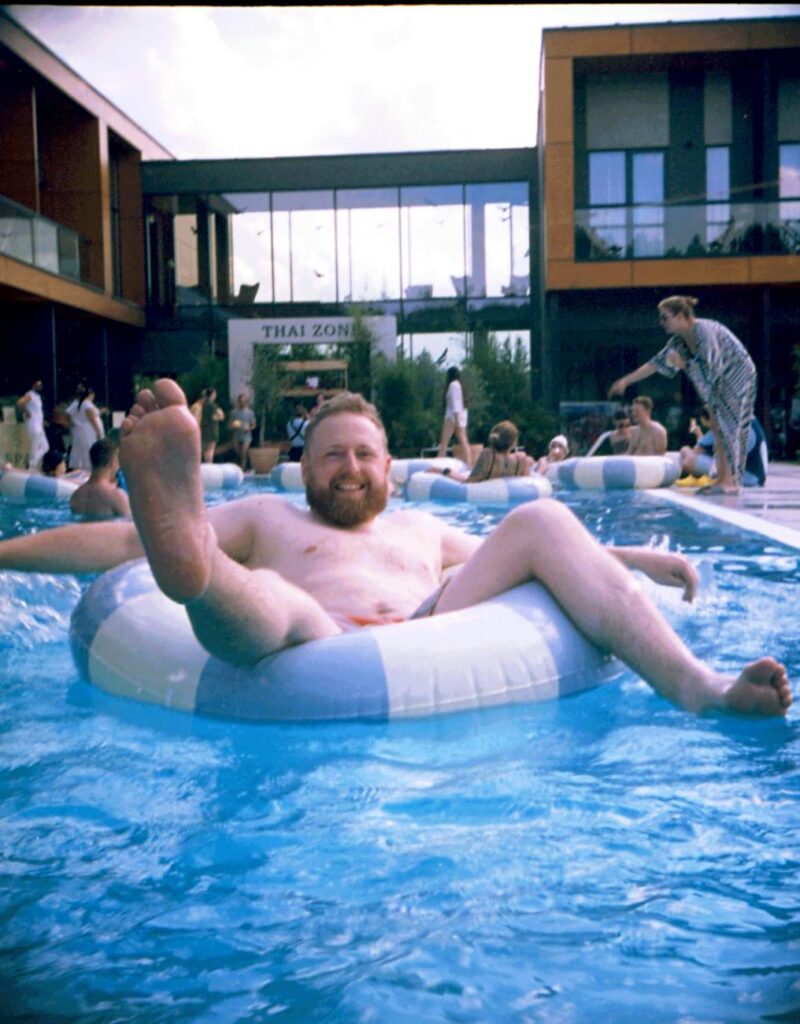 man relaxing on pool float in resort