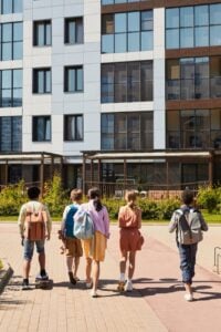 people walking towards the concrete building
