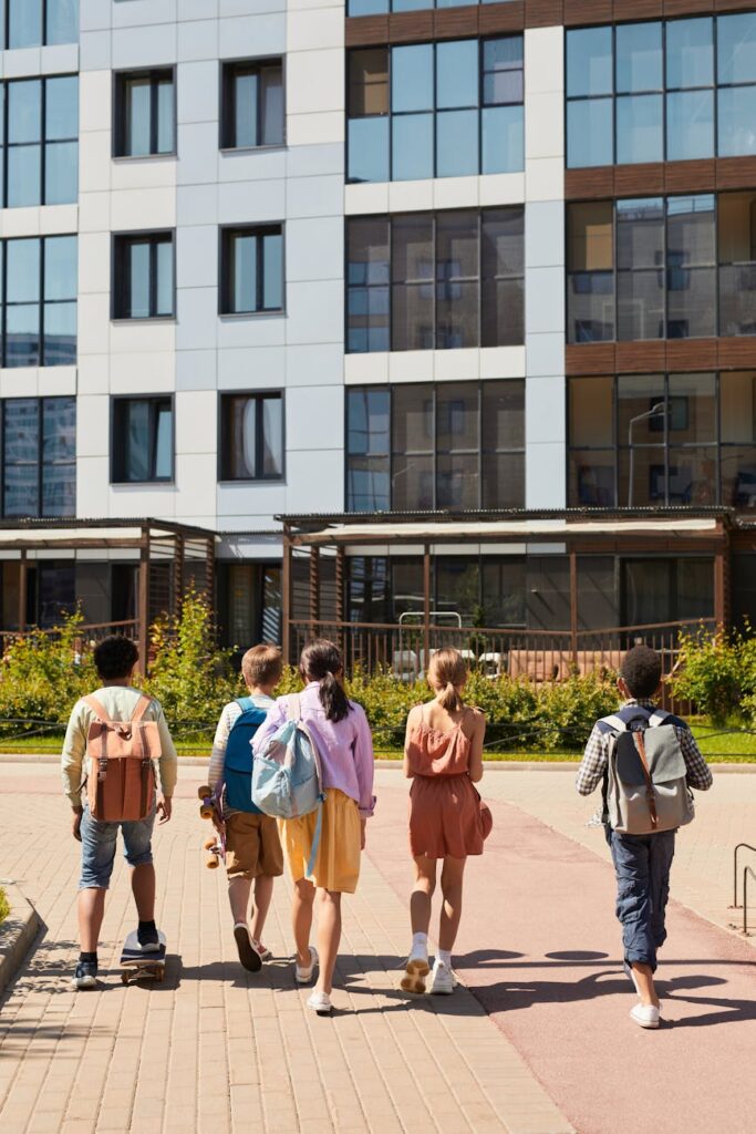 people walking towards the concrete building