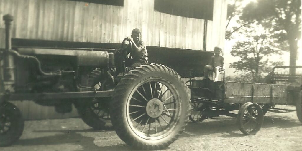 Ellington, CT, USA, Summer of 1928: Fred driving 1928 Farmall tractor, Martin is sitting on the wagon