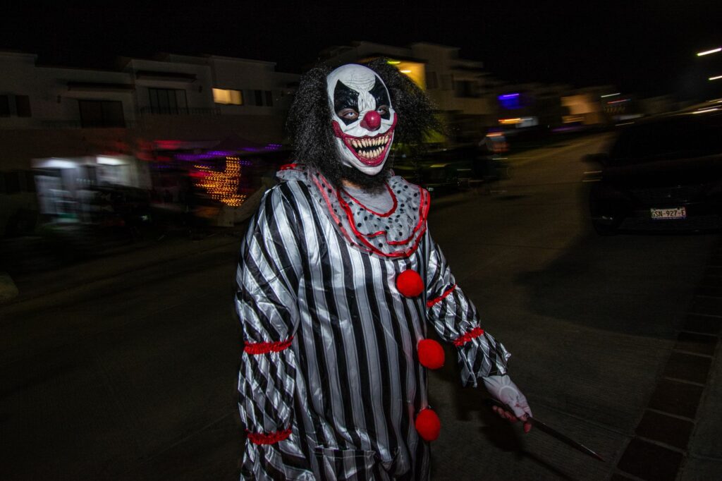 photo of a spooky clown on a street by night