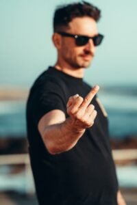 man showing middle finger outdoors in daylight